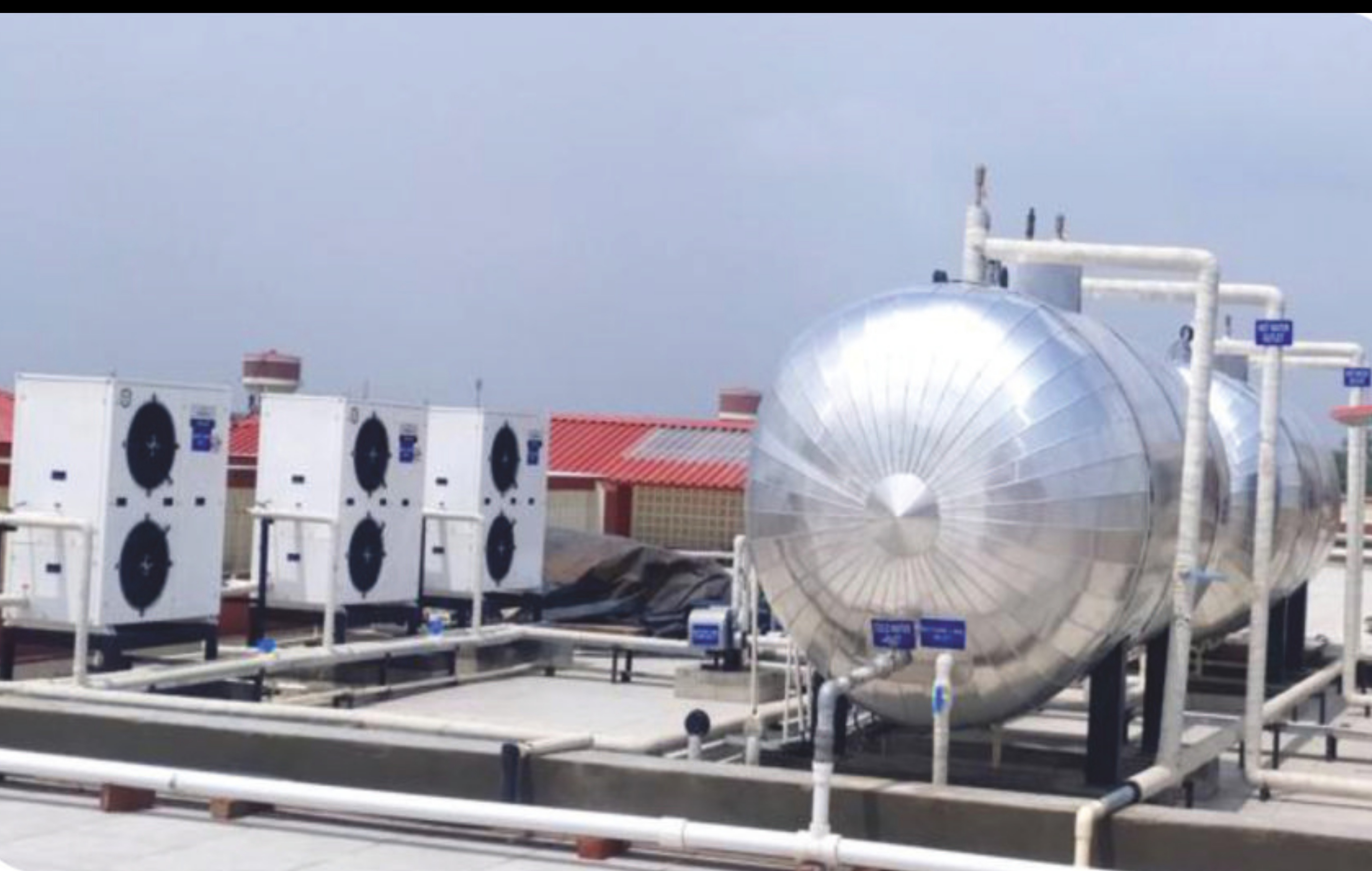 ALMIC Industrial Heat Pump installation with multiple outdoor units and a large hot water storage tank on a commercial rooftop