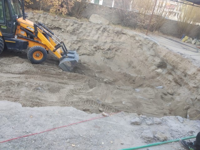 Excavator working the rocky excavation for the Thiksey geothermal field